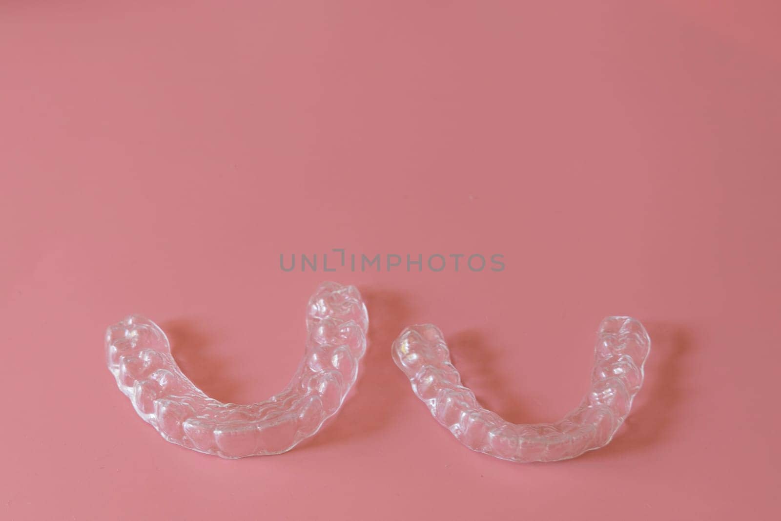 Transparent aligners, invisalign bracer smile isolated on pastel light pink background