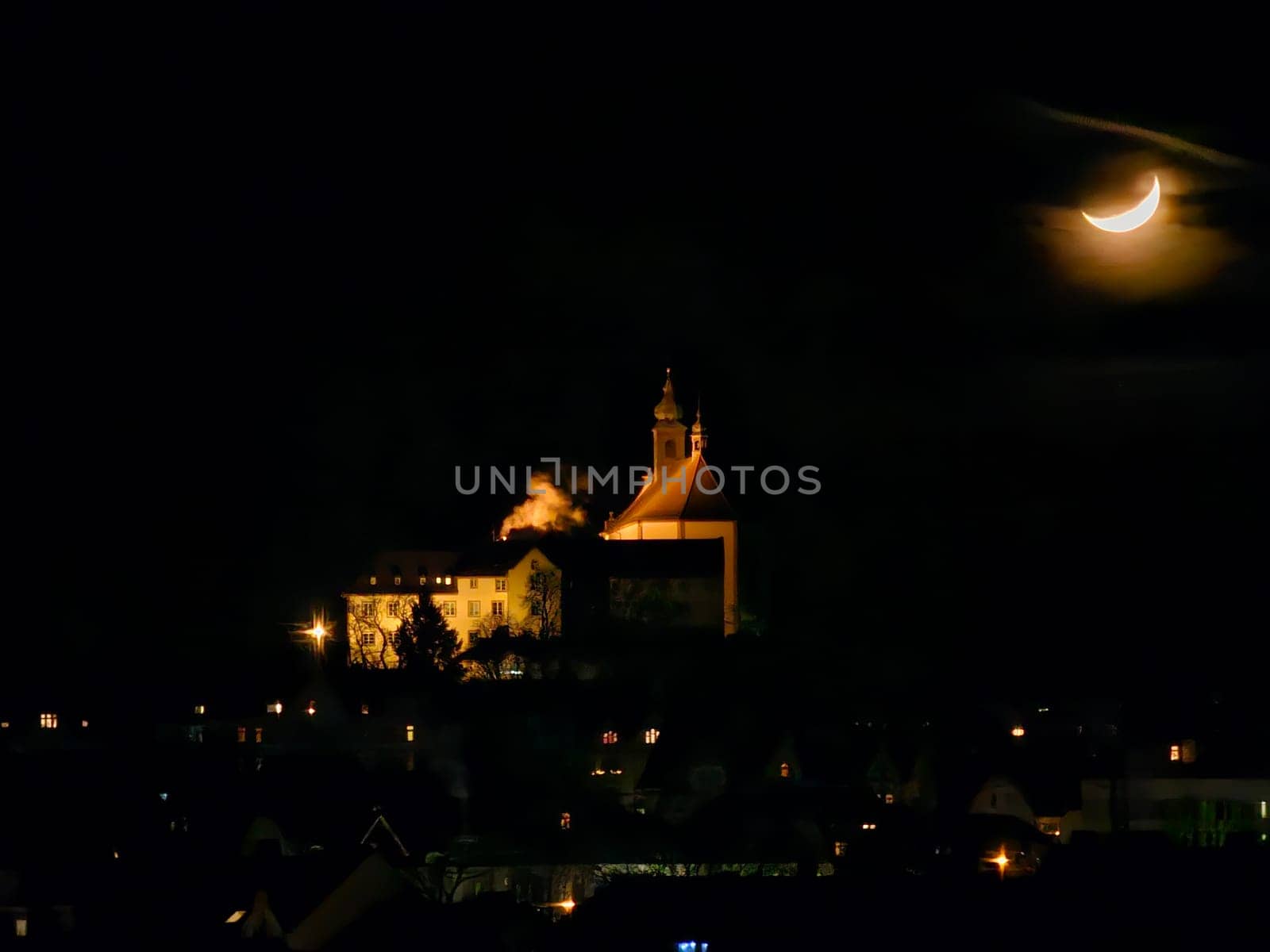 Franziskanerkloster Frauenberg mit Stiftskirche in Fulda, Deutschland, bei Nacht im Mondlicht und hellen Lichtern, in der Ferne. High quality photo