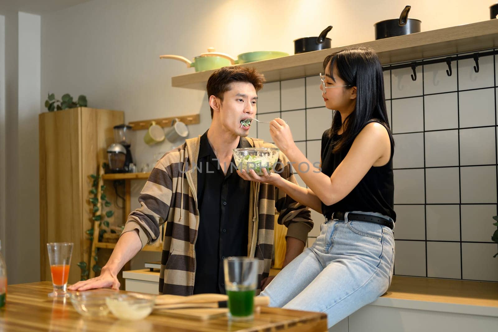 Young couple enjoying cooking and tasting together in the Kitchen.