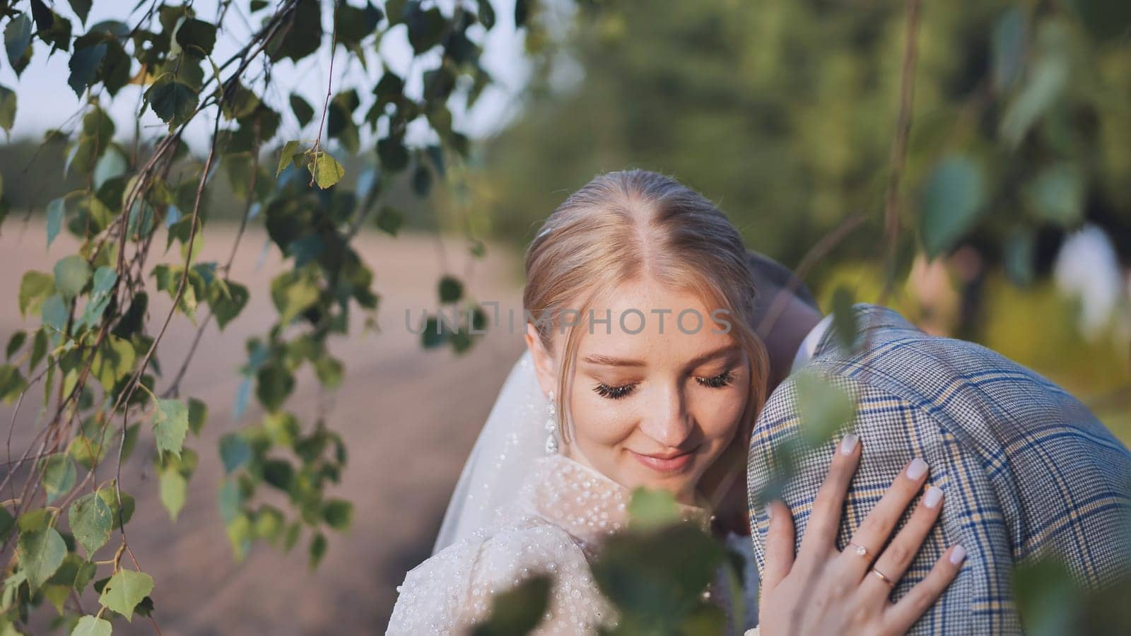 Romantic newlywed couple embracing under birch tree branches, celebrating their love and commitment on their wedding day