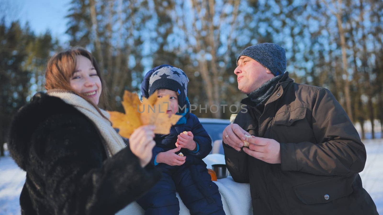 Happy family enjoying a winter picnic in a snowy forest, sharing delicious food and creating joyful memories together in nature