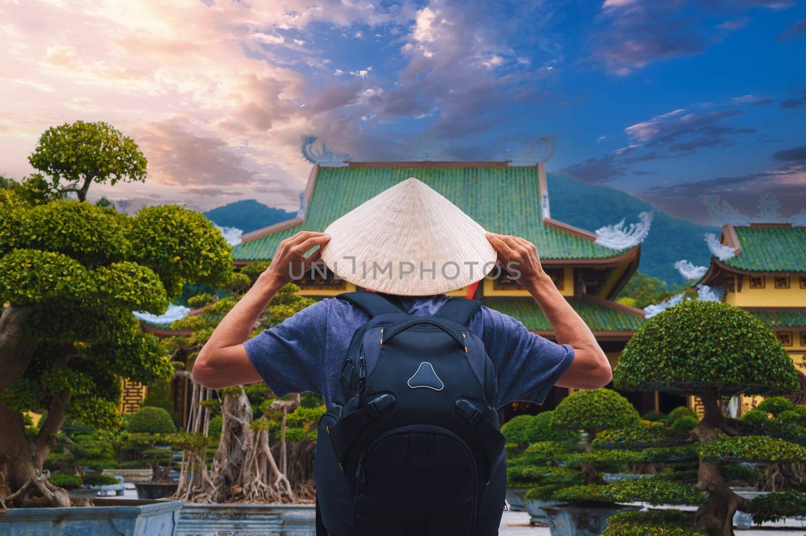 back of male tourist traveler at a Buddhist temple at Linh Ung Pagoda in Da Nang in Vietnam. Concept of travel and tourism in Asia