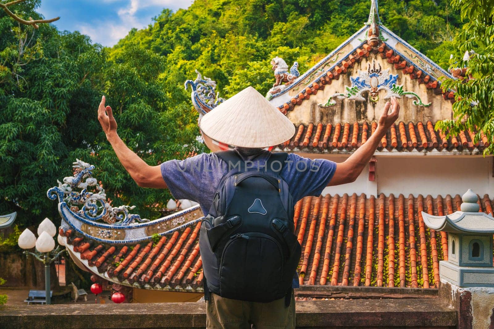 back of a male tourist traveler at the temple on the Buddhist pagoda in Da Nang, Vietnam. Travel and tourism in Asia