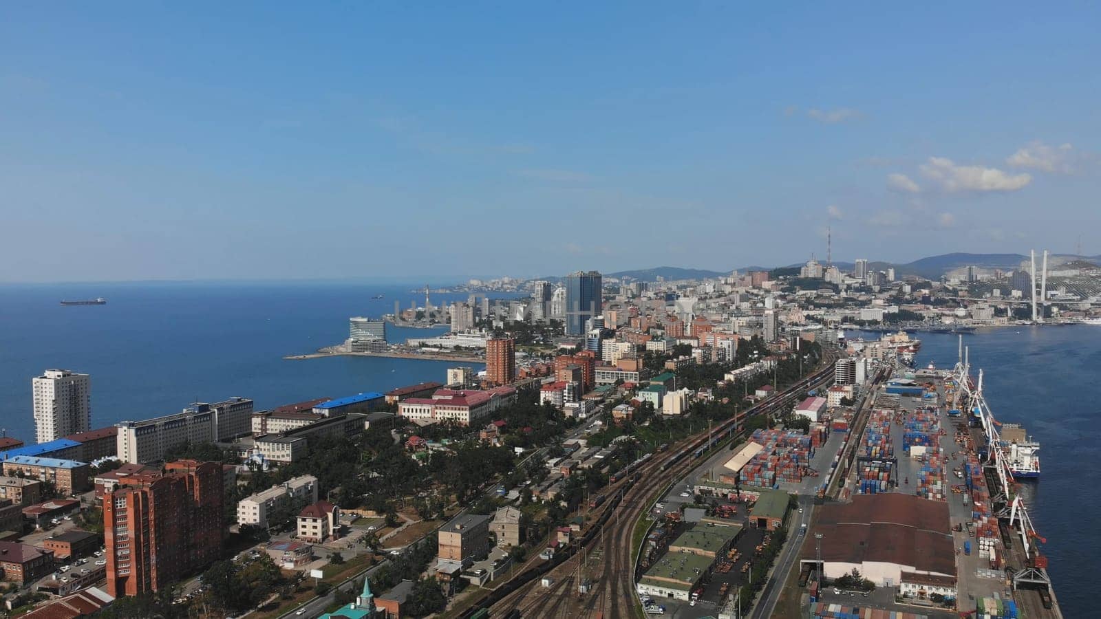 Aerial panorama revealing vladivostok's urban landscape, maritime infrastructure, zolotoy rog bay, and iconic russky bridge against pristine skyline