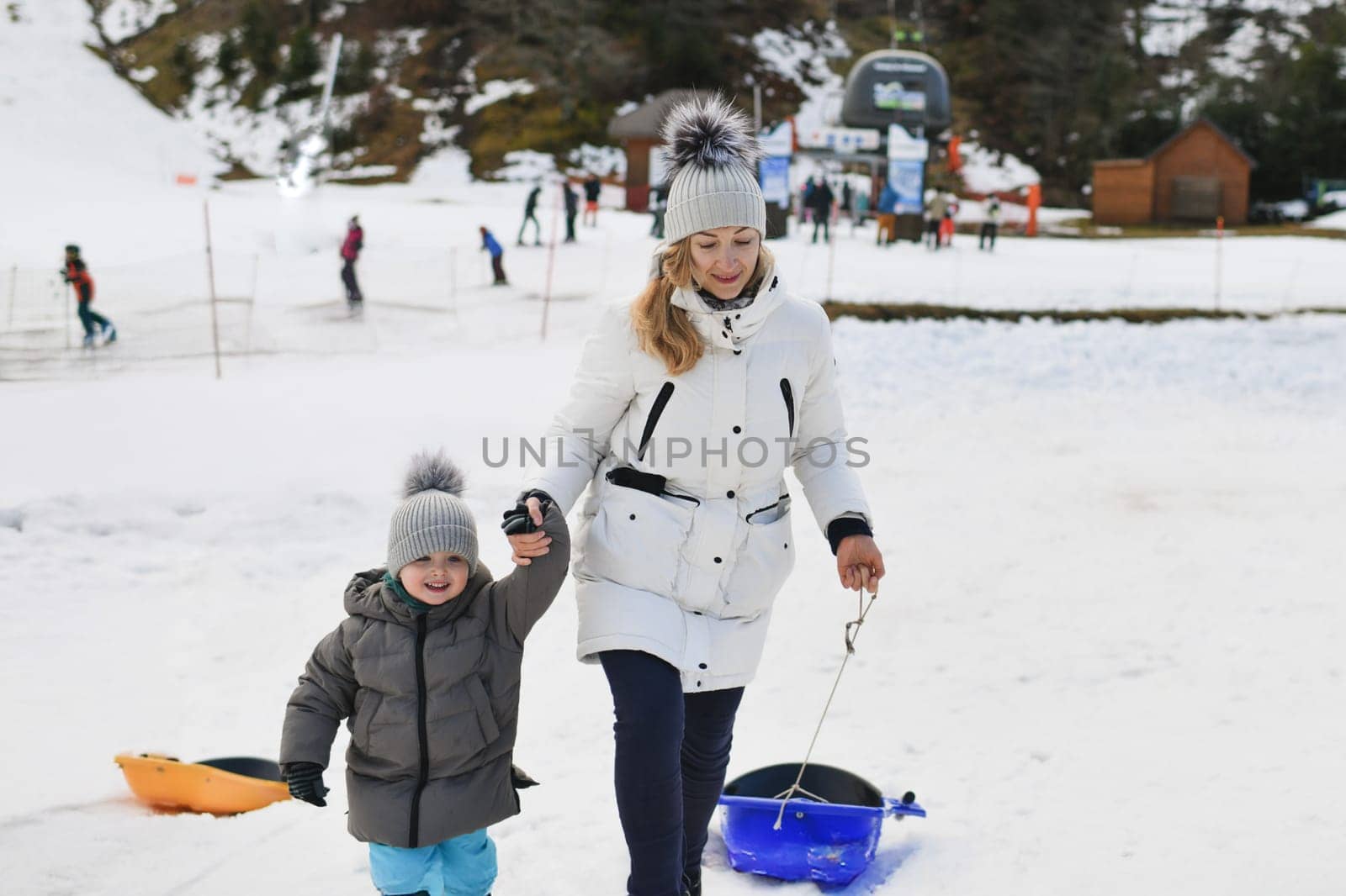 The mother with child sledding in the snow