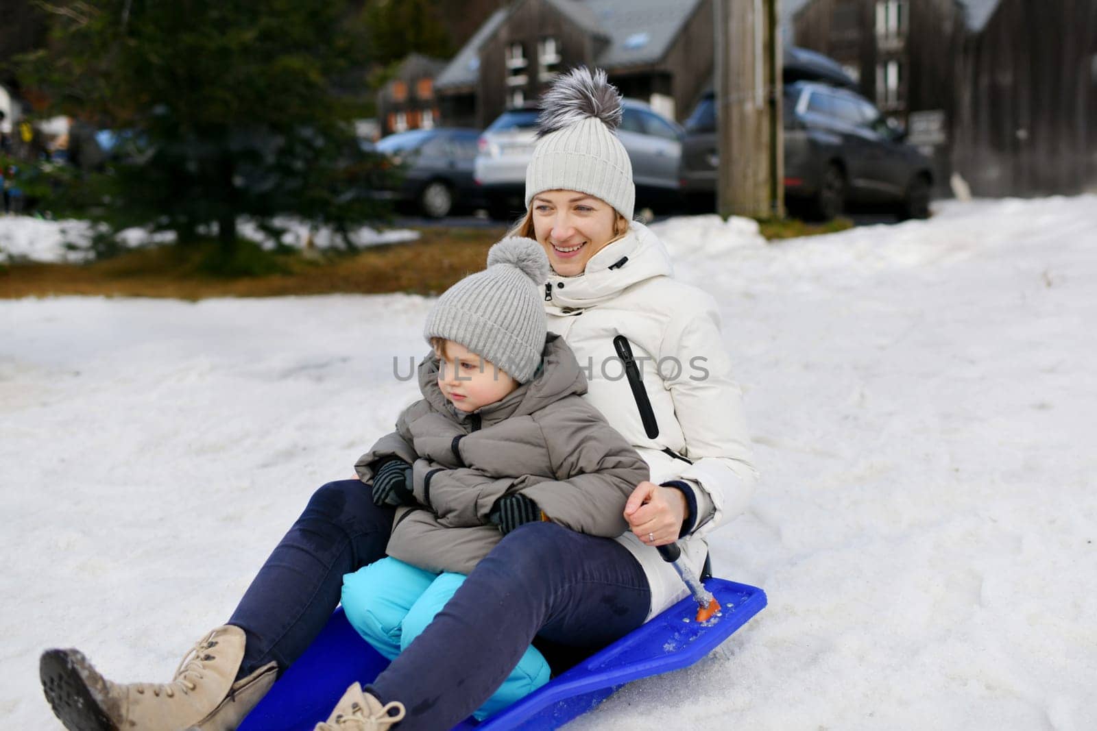 The mother with child sledding in the snow