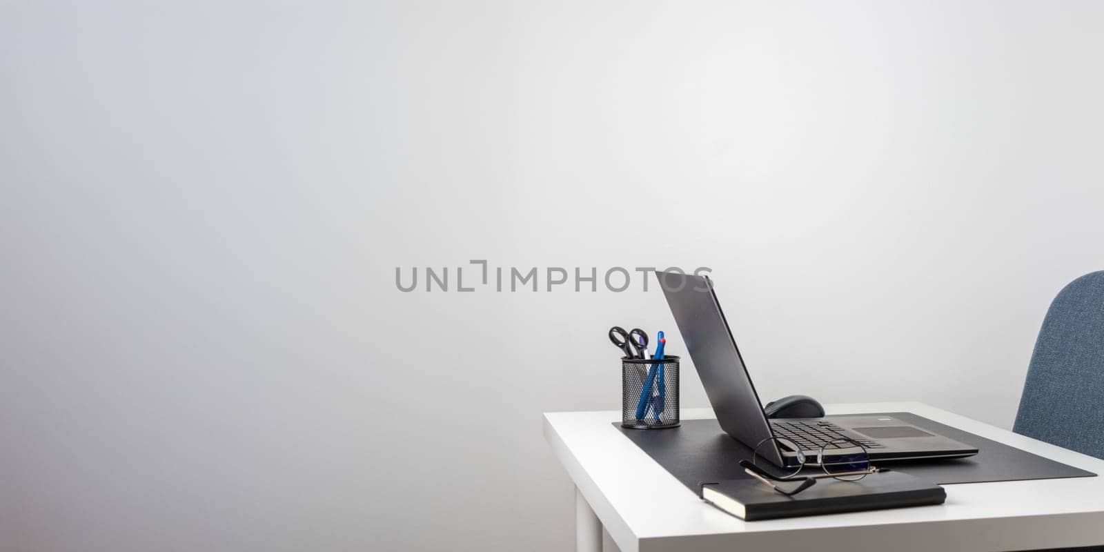 Laptop computer, notebook, and eyeglasses and headphones on a desk, place for work and study, home freelancer's office