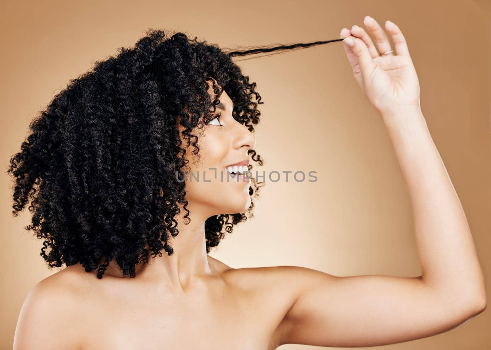 Hair, woman with curls and beauty, salon treatment for shine, cosmetic care and smile on studio background. Wellness, haircare and model with strong texture and curly hairstyle, volume and afro by YuriArcurs
