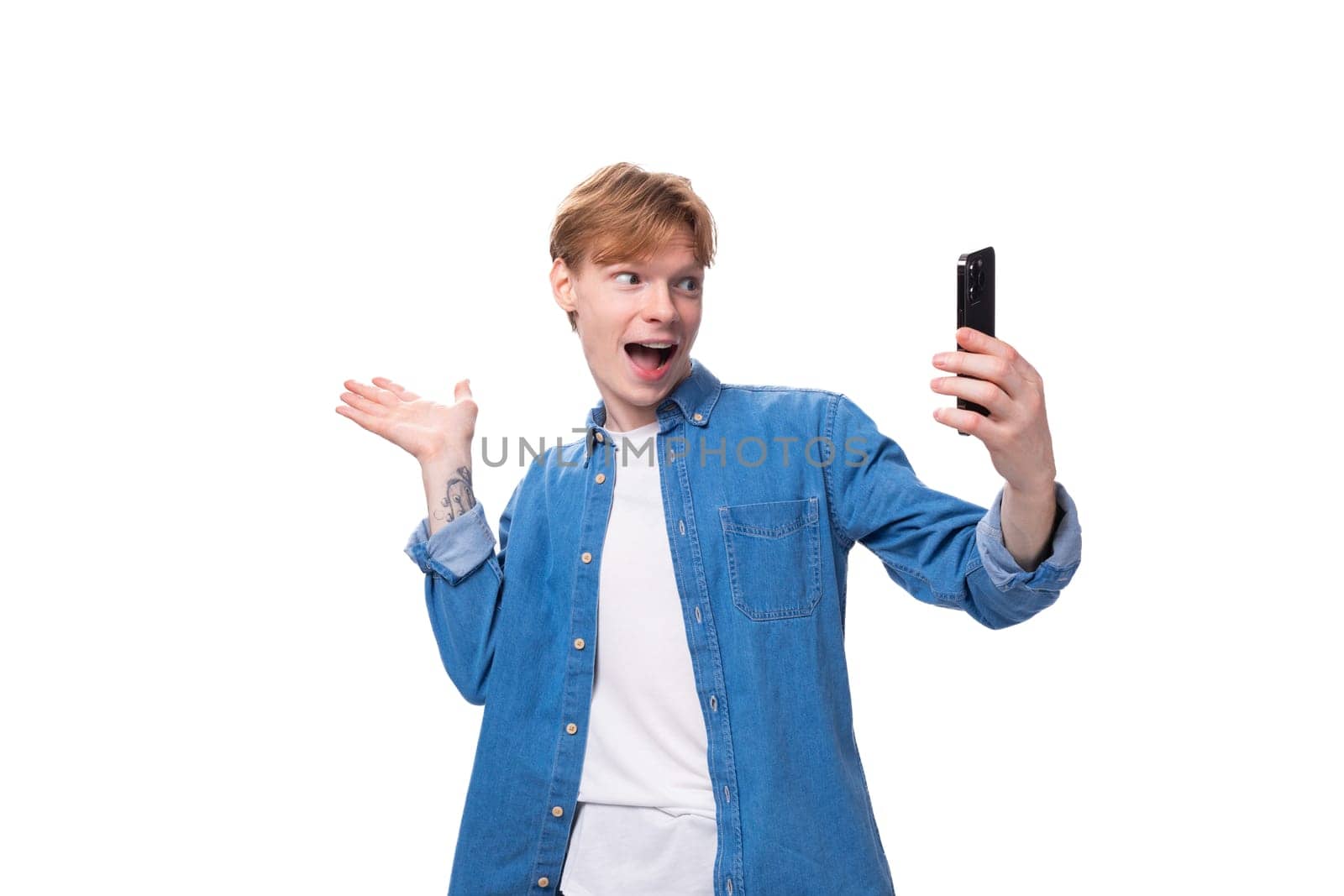 a young european guy with golden hair conducts a video broadcast on a smartphone.