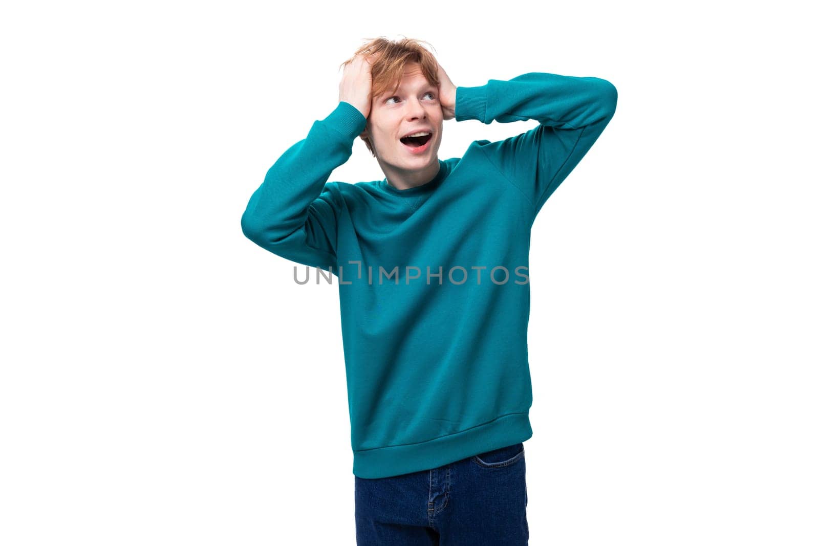 handsome redhead young man in blue sweater shows surprise.