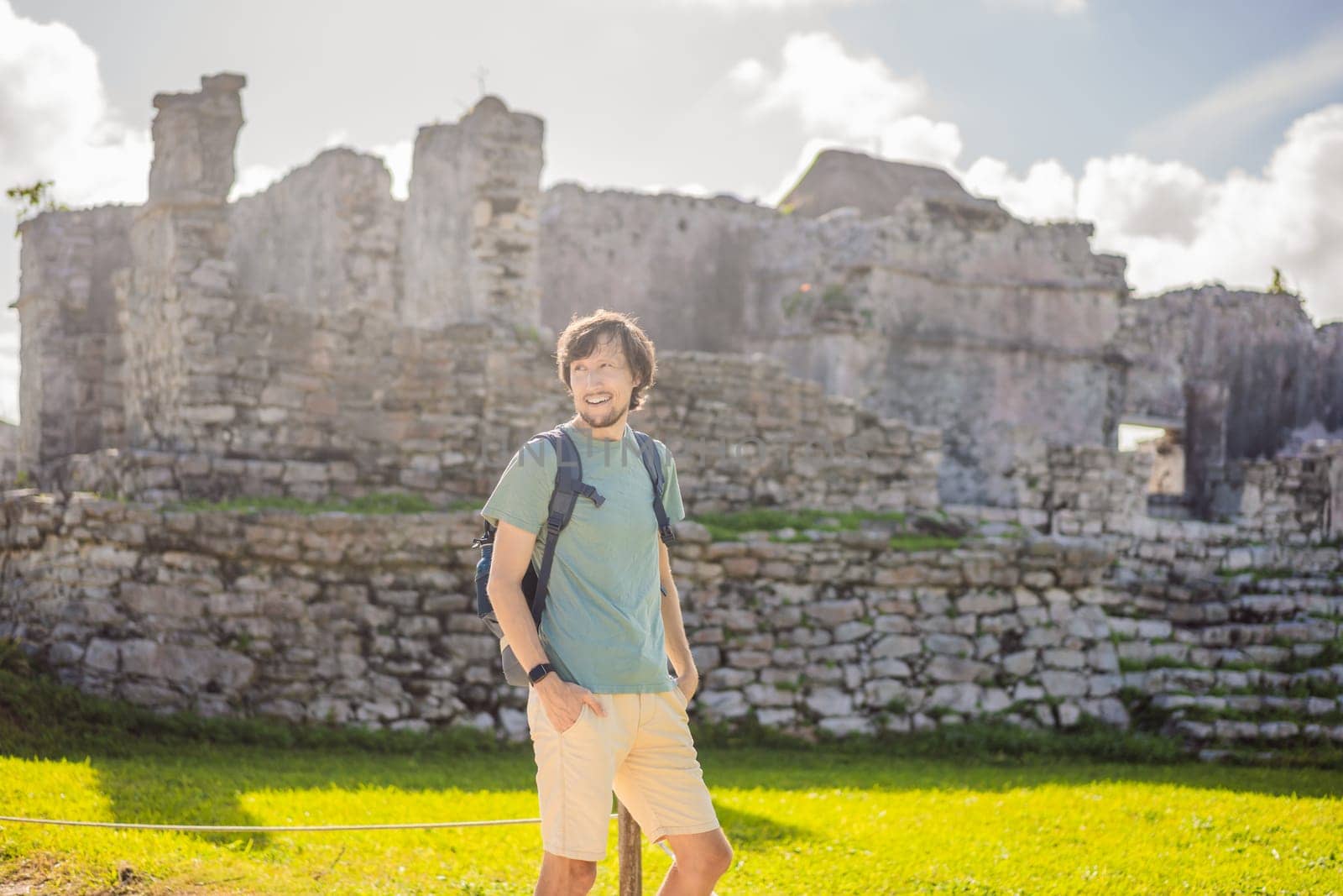 Male tourist enjoying the view Pre-Columbian Mayan walled city of Tulum, Quintana Roo, Mexico, North America, Tulum, Mexico. El Castillo - castle the Mayan city of Tulum main temple by galitskaya