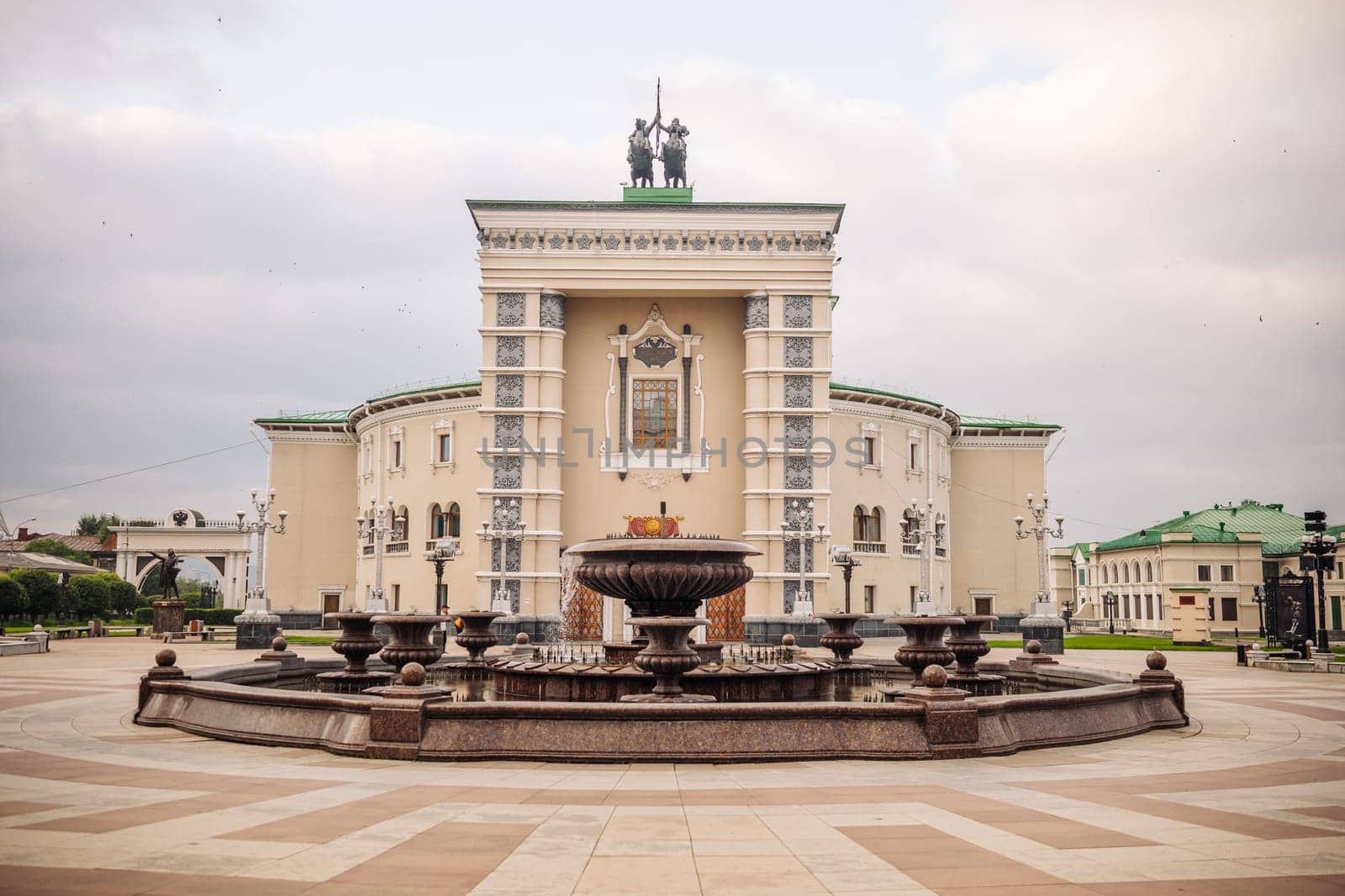 Musical theatre complex rising dramatically near ornate fountain in yoshkar ola, russia, showcasing architectural grandeur of regional cultural landmark
