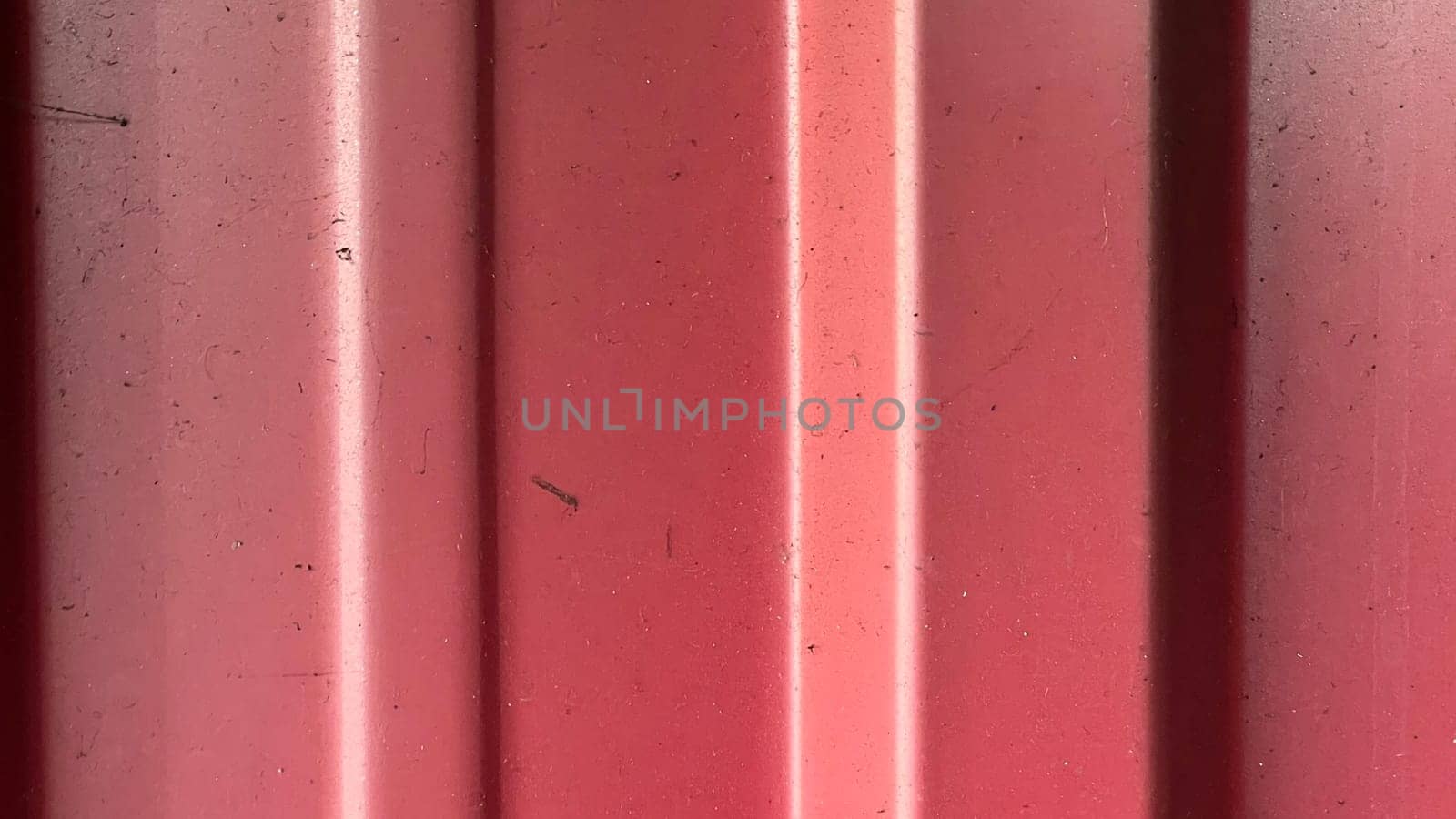 A close-up view highlights the vibrant red hue and textured lines under bright light.