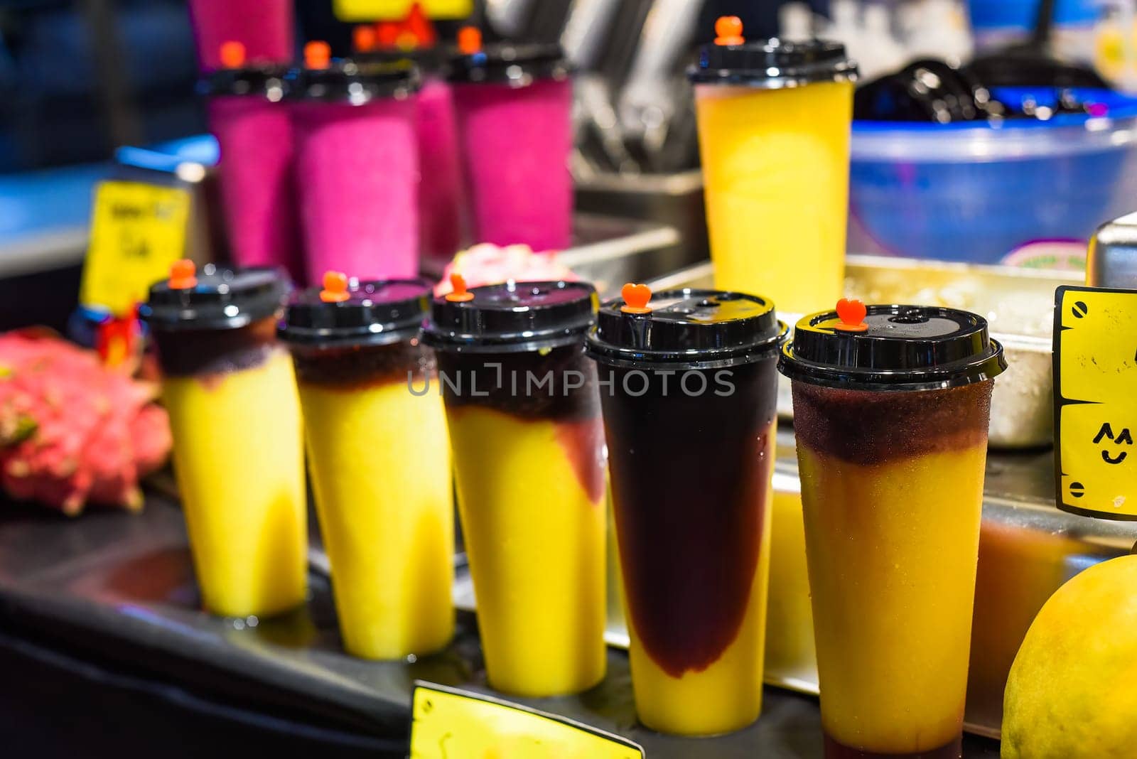 Many smoothie and drinks in plastic cups in Jalan Alor street food in the Kuala Lumpur market