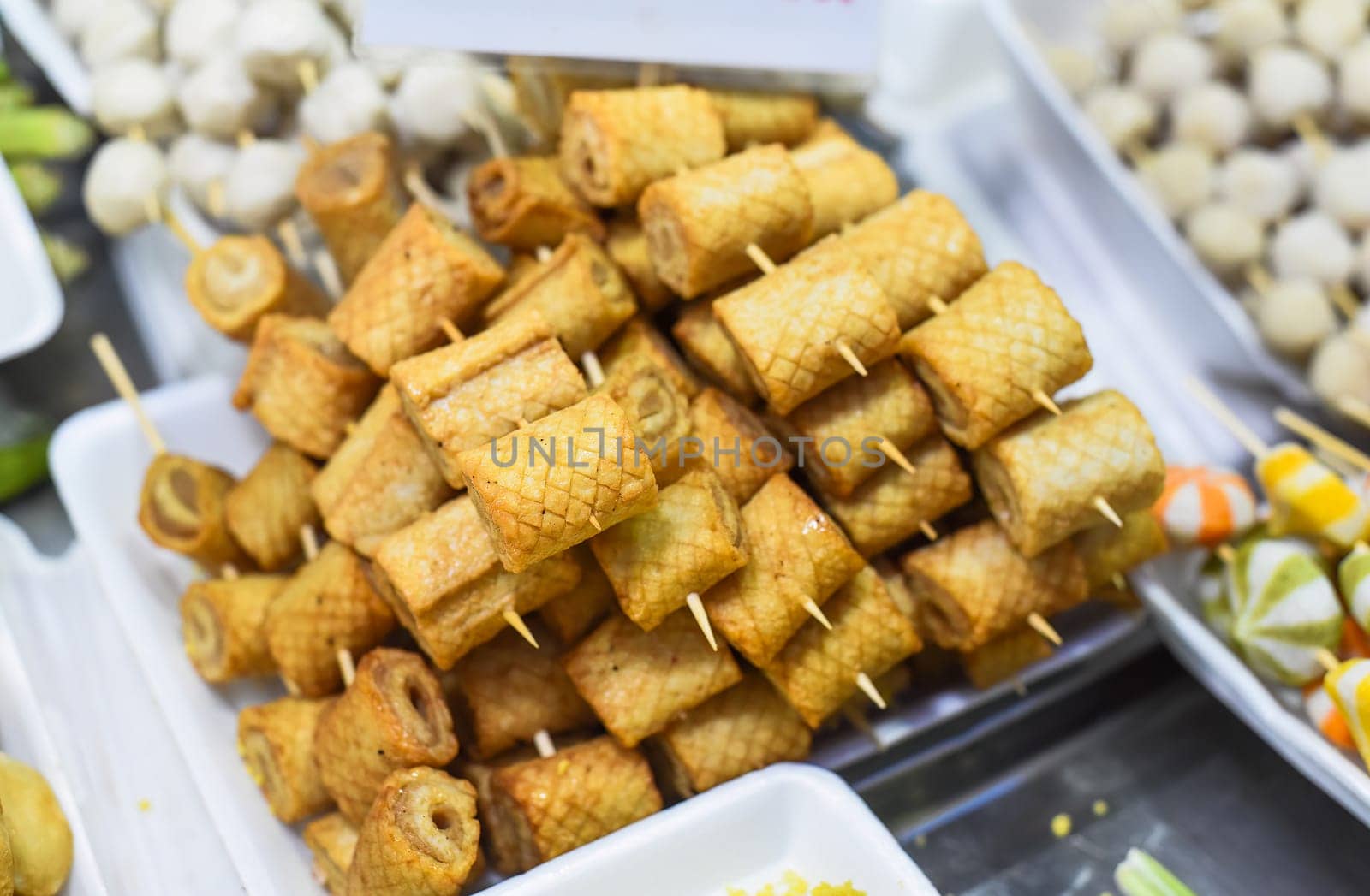 Many snacks and seafood in vietnamese night market in food festival, sign "beef ball, fish ball, price 10 000 dongs"