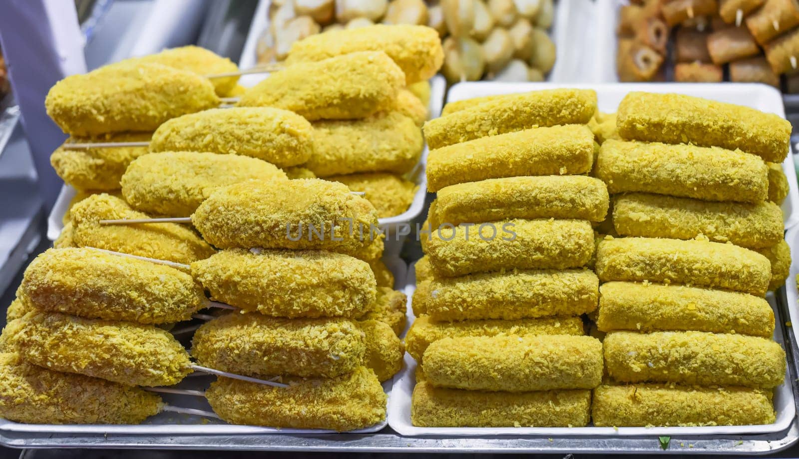 Many snacks and seafood in vietnamese night market in food festival, sign "beef ball, fish ball, price 10 000 dongs"