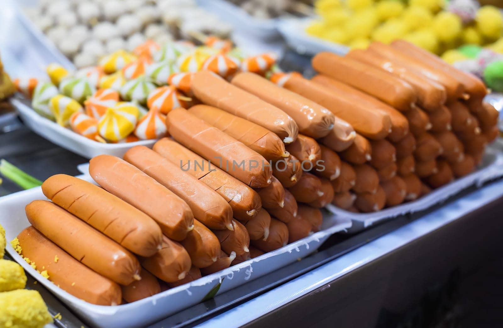 Many snacks and seafood in vietnamese night market in food festival, sign "beef ball, fish ball, price 10 000 dongs"