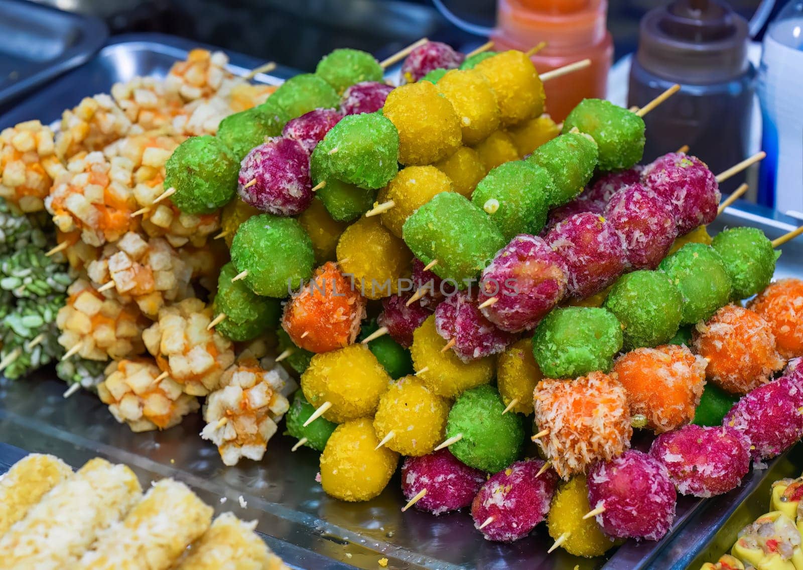 Many snacks and seafood in vietnamese night market in food festival, sign "beef ball, fish ball, price 10 000 dongs"