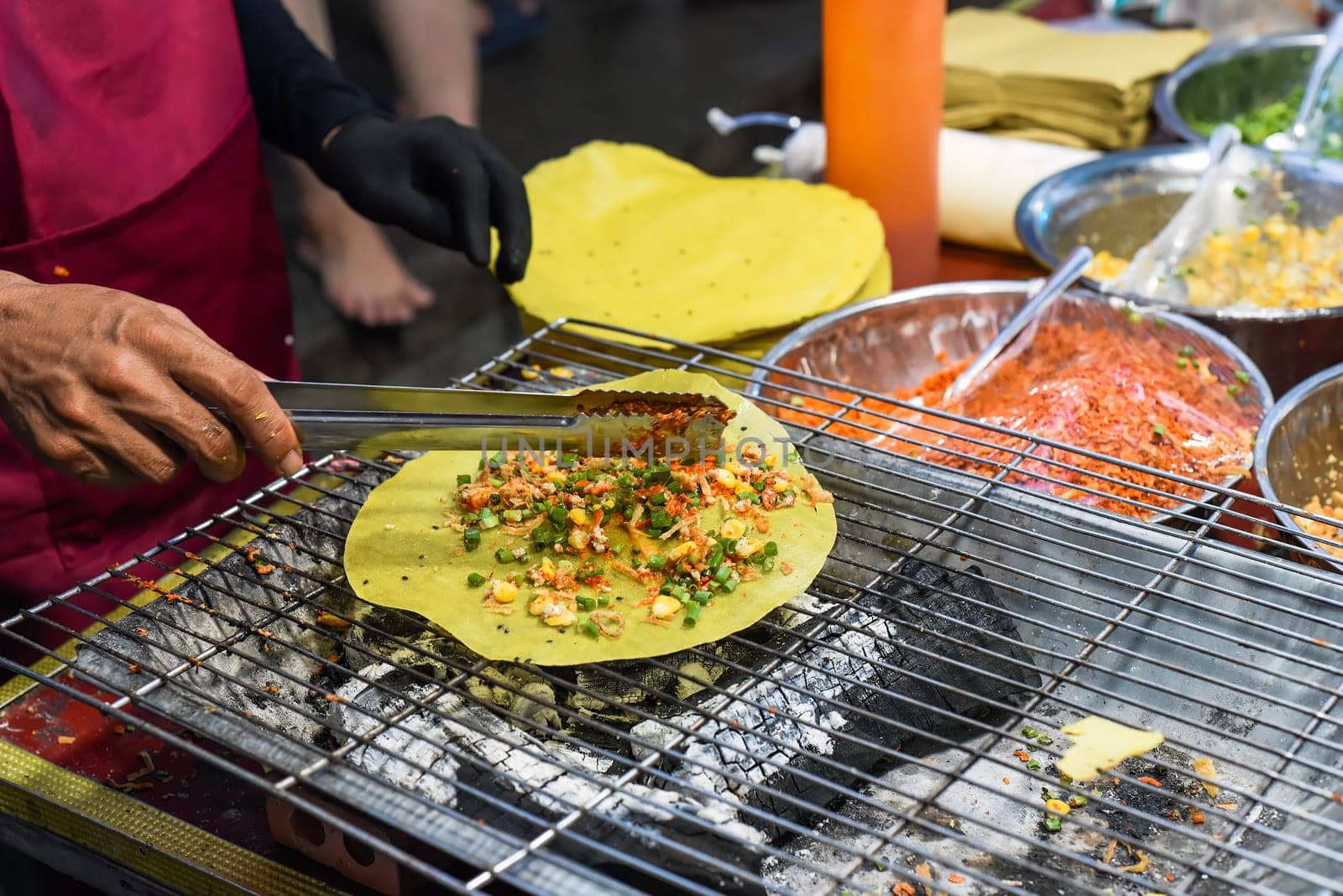 Grilled vietnamese pancake with eggs, sausages and sauces in vietnamese night market in food festival