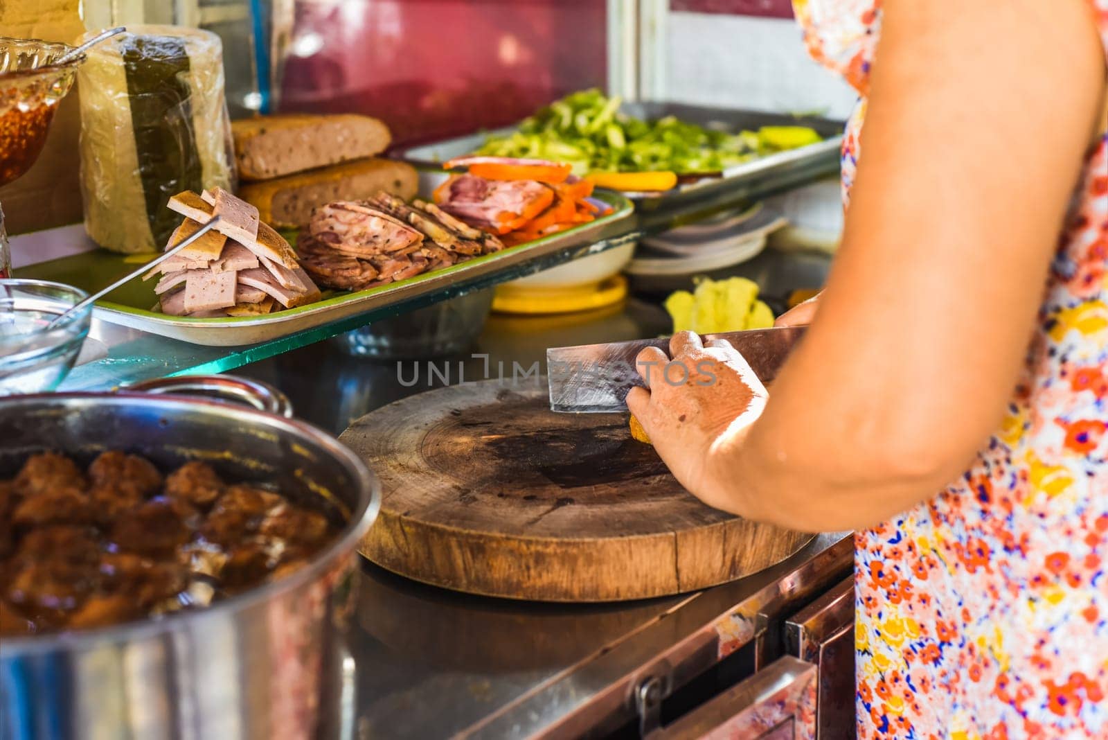 Vietnamese woman preparing ingredients for making traditional Banh Me on street food in Nha Trang