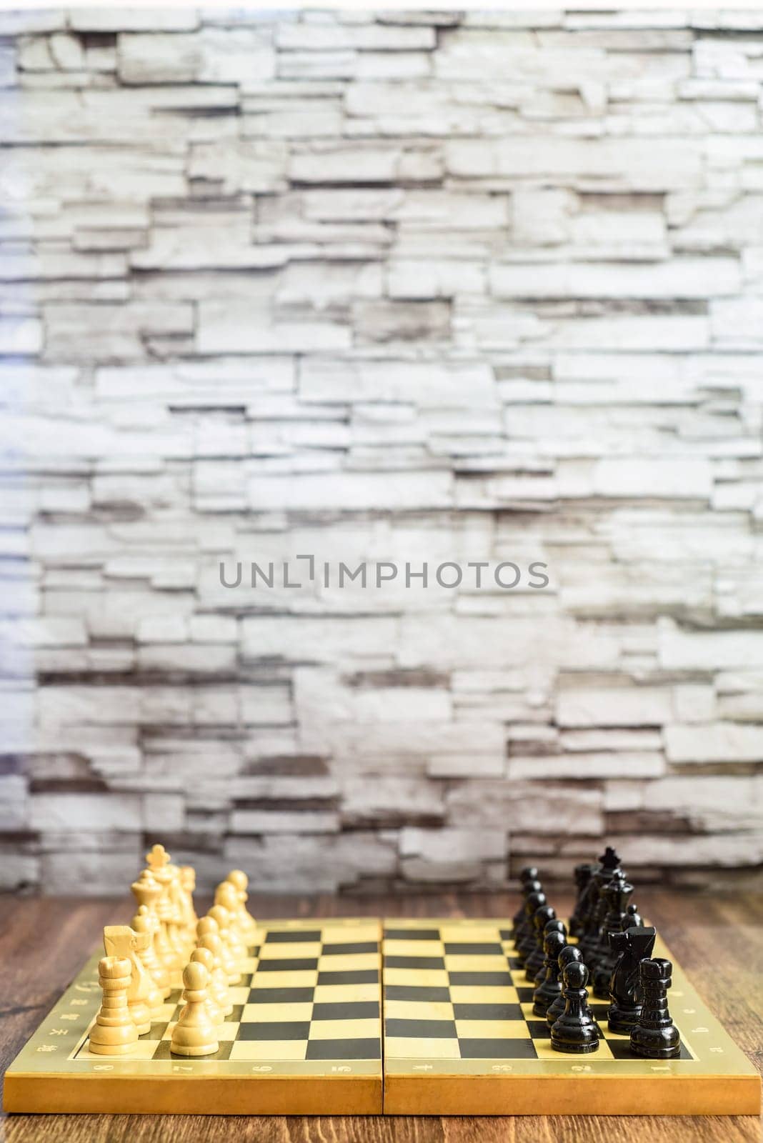 Chess pieces on chess board on wooden table. Blurred background with copy space