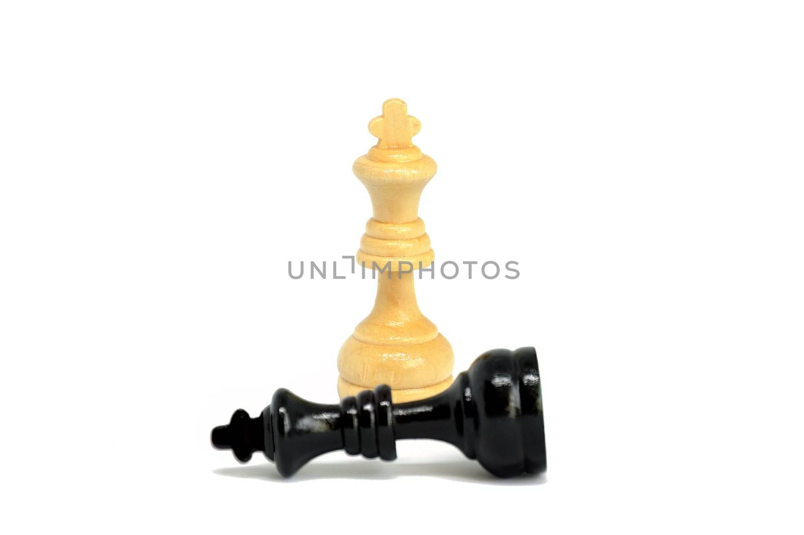 The white king defeated black king  isolated on white background. Blurred black king