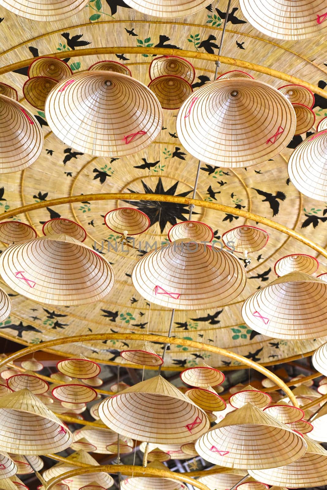 Many similar traditional Vietnamese conical hats attached to the ceiling for decoration a holiday