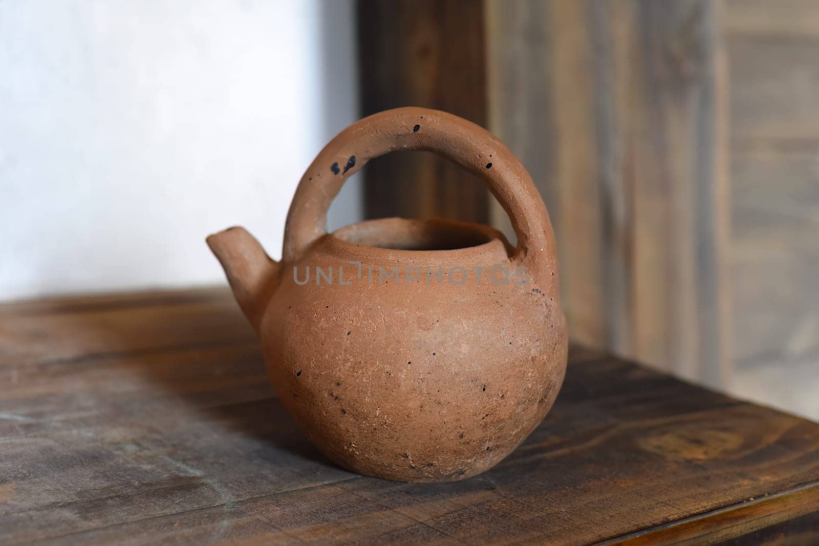 Clay teapot on artificial hearth