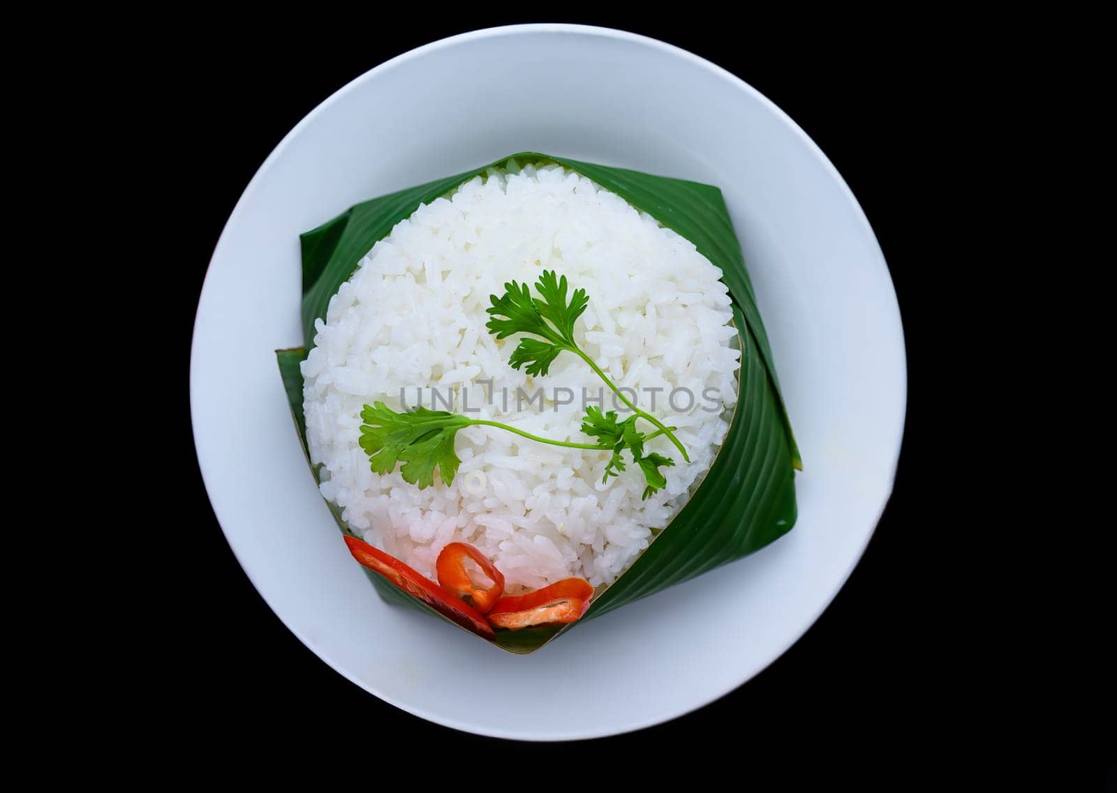 Vietnamese white rice in banana leaf isolated on black background for a menu