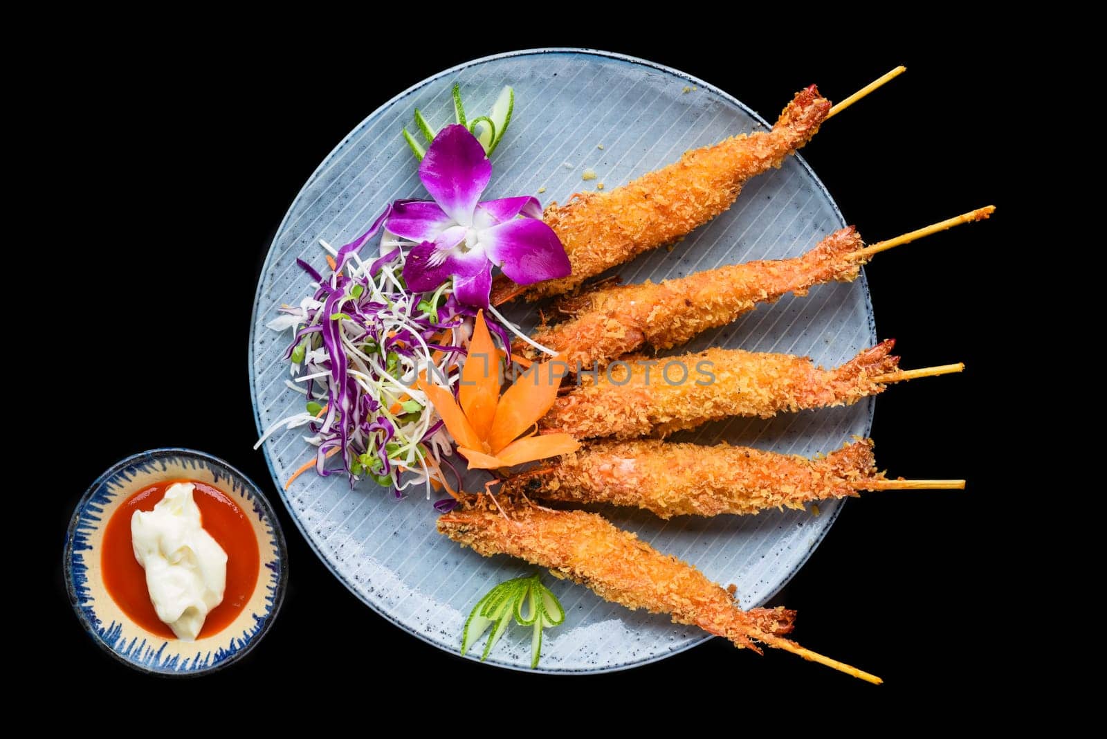 Fried shrimps in batter with red sauce isolated on black background top view