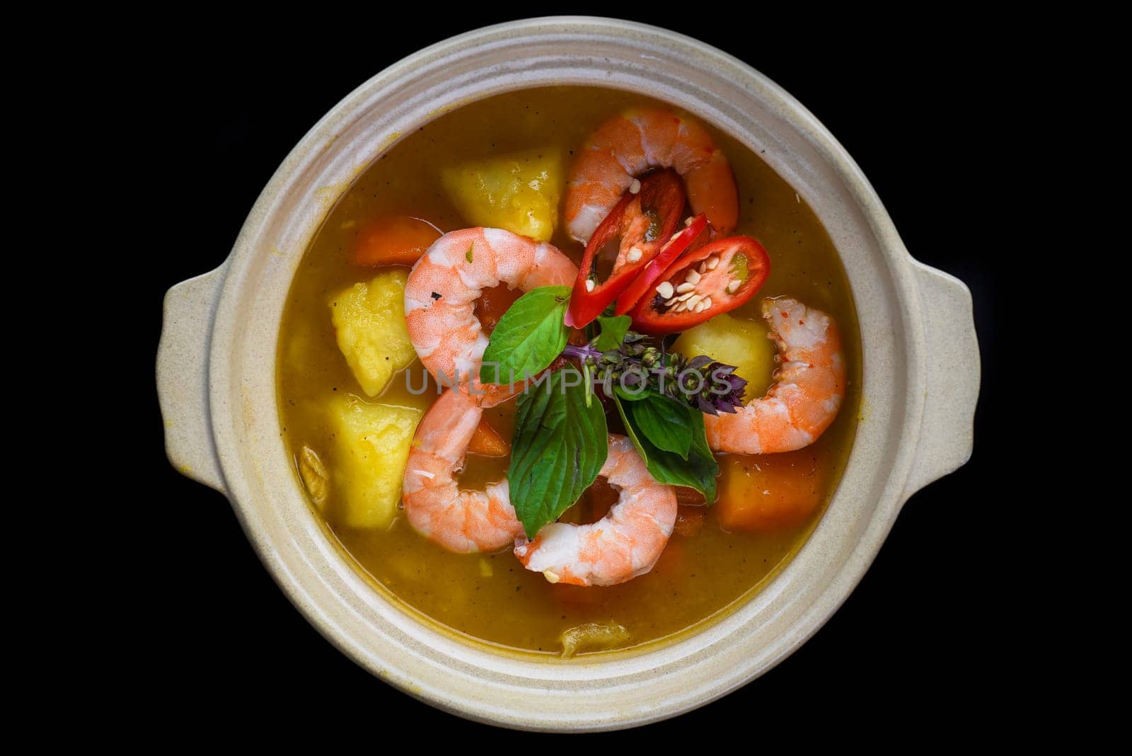 Stew with shrimps and pineapple  isolated on black background top view