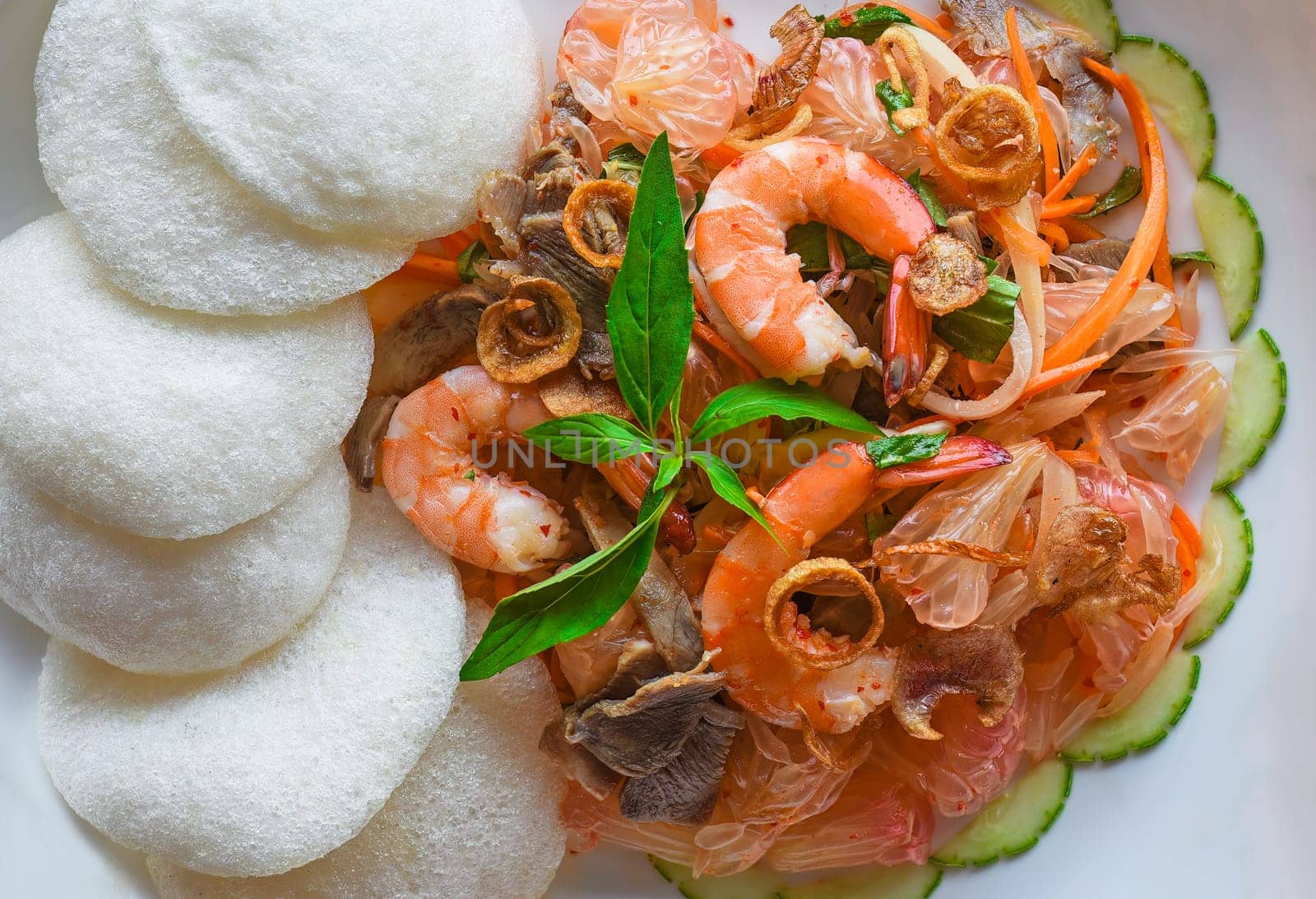 Salad made of shrimps and grapefruit isolated on black background top view