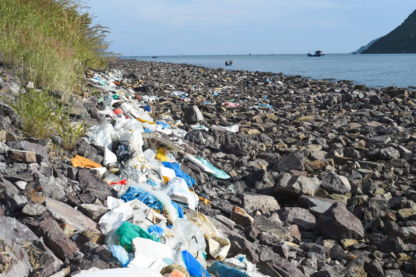 Terrible view of dirty beach in Khanh Hoa province with much trash on stones