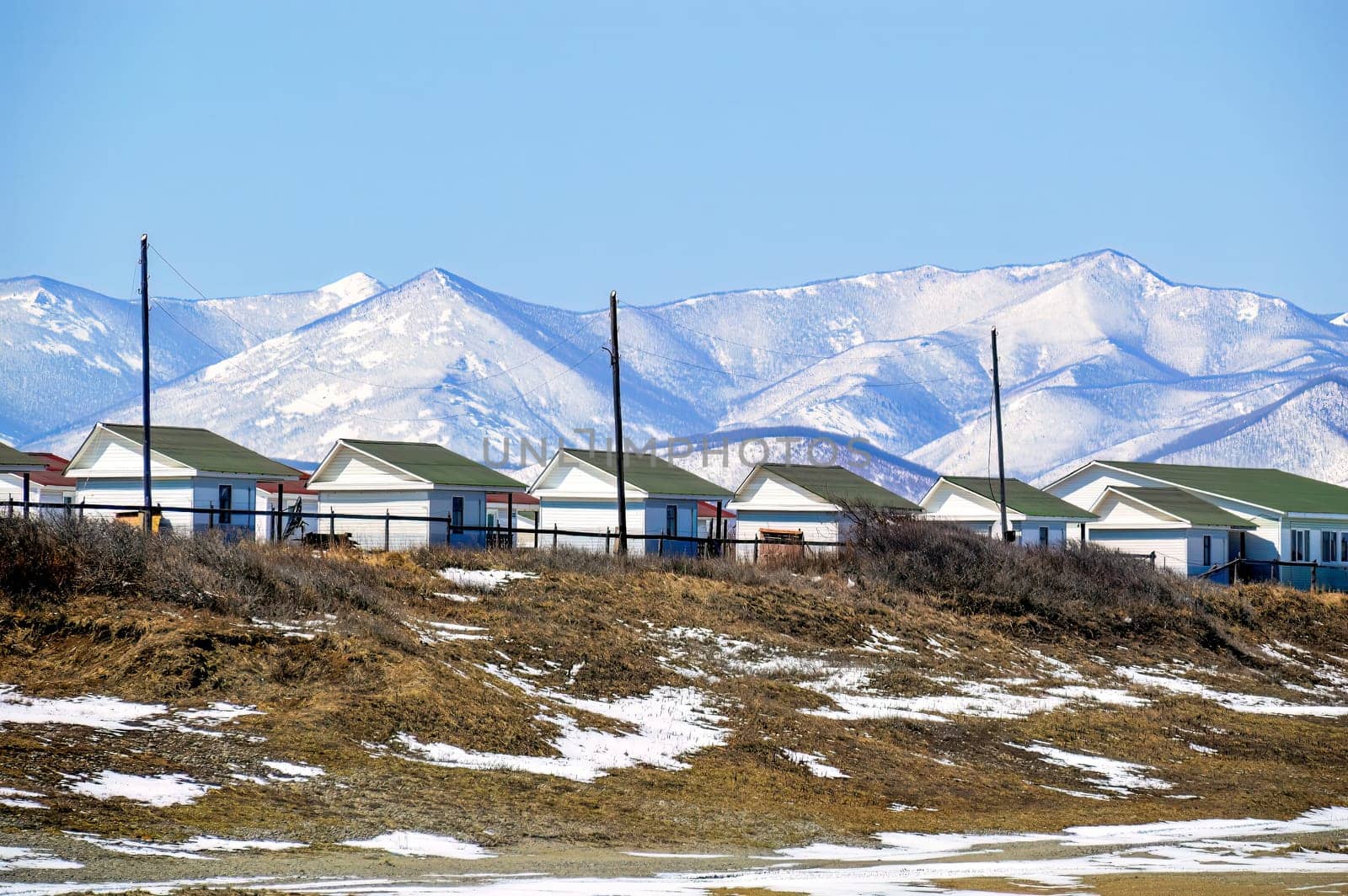 Many identical houses for camping and basing at the foot of the snowy mountains. Far East, Russia