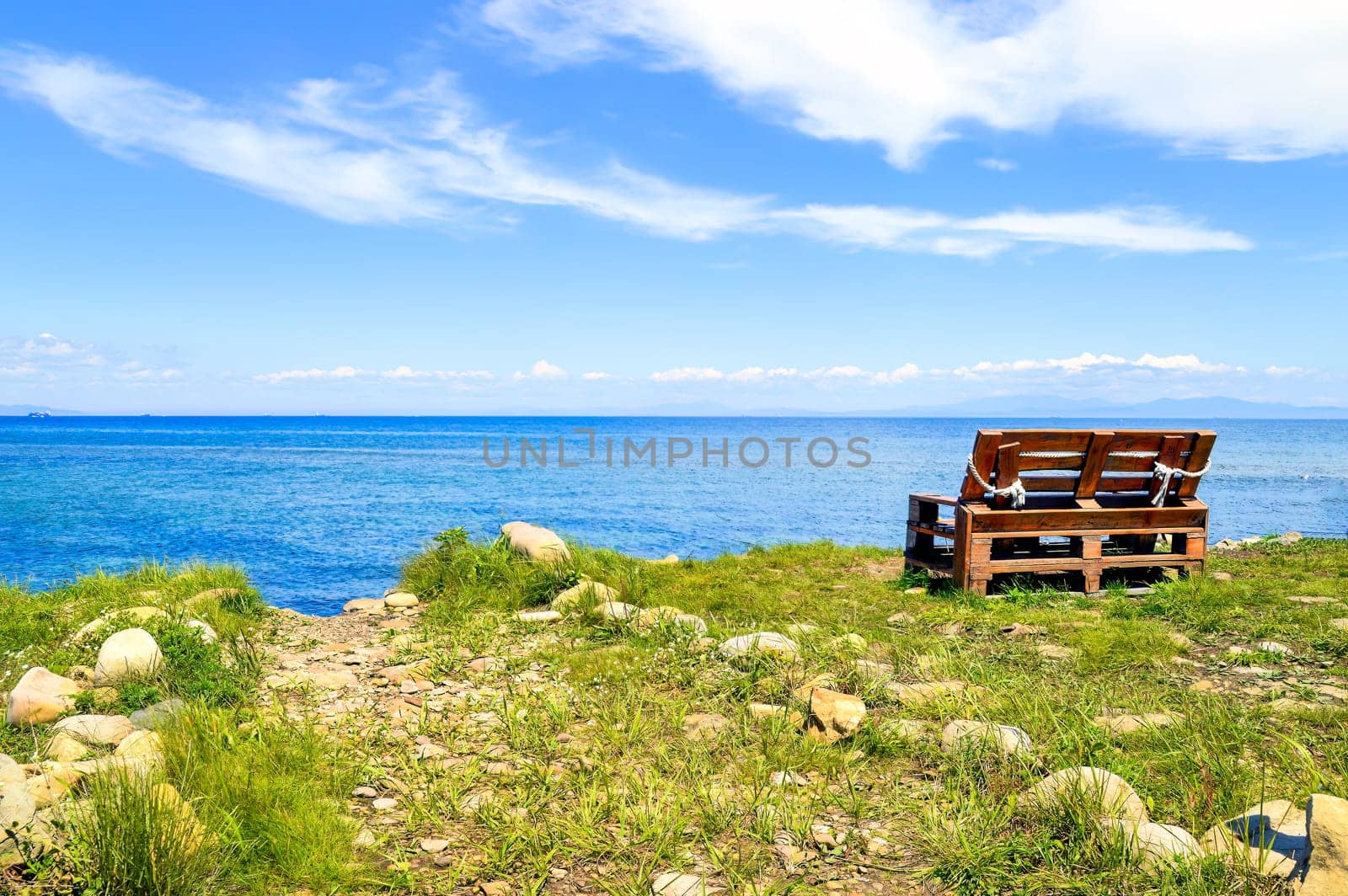 Wooden old bench without people on the background of the Japanese sea on a summer day