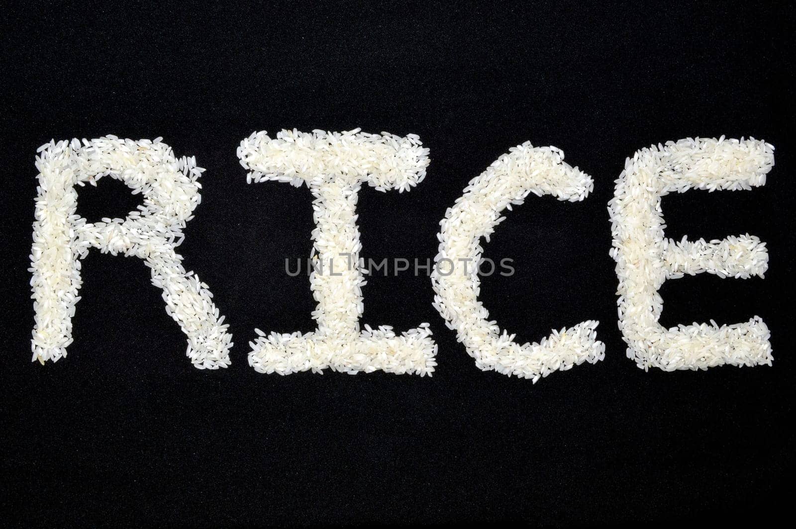 Word arts "Rice" made of rice grain on black background