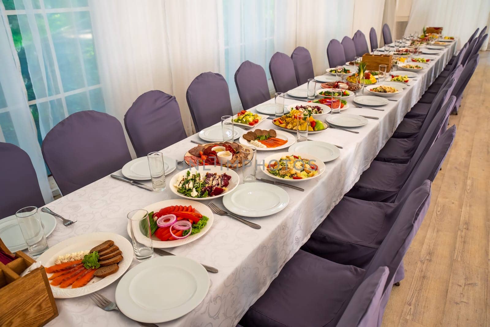 festive table set with Caesar salads, beets, fruit plate without people