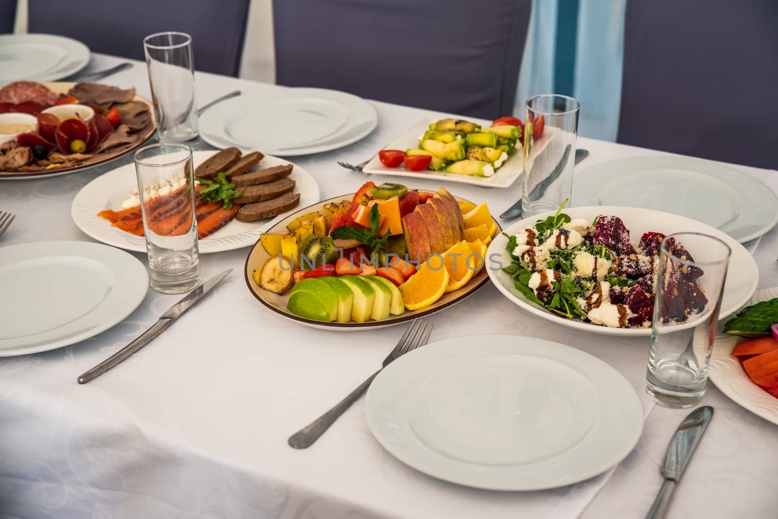festive table set with Caesar salads, beets, fruit plate without people