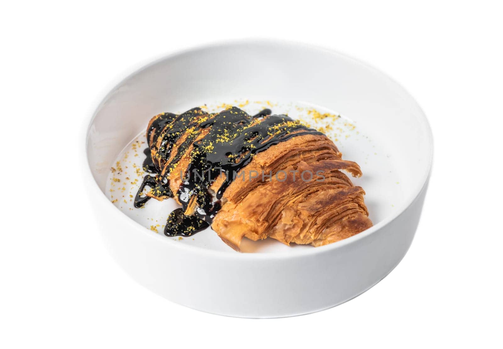 Sweet croissant with chocolate syrup in white plate on white background