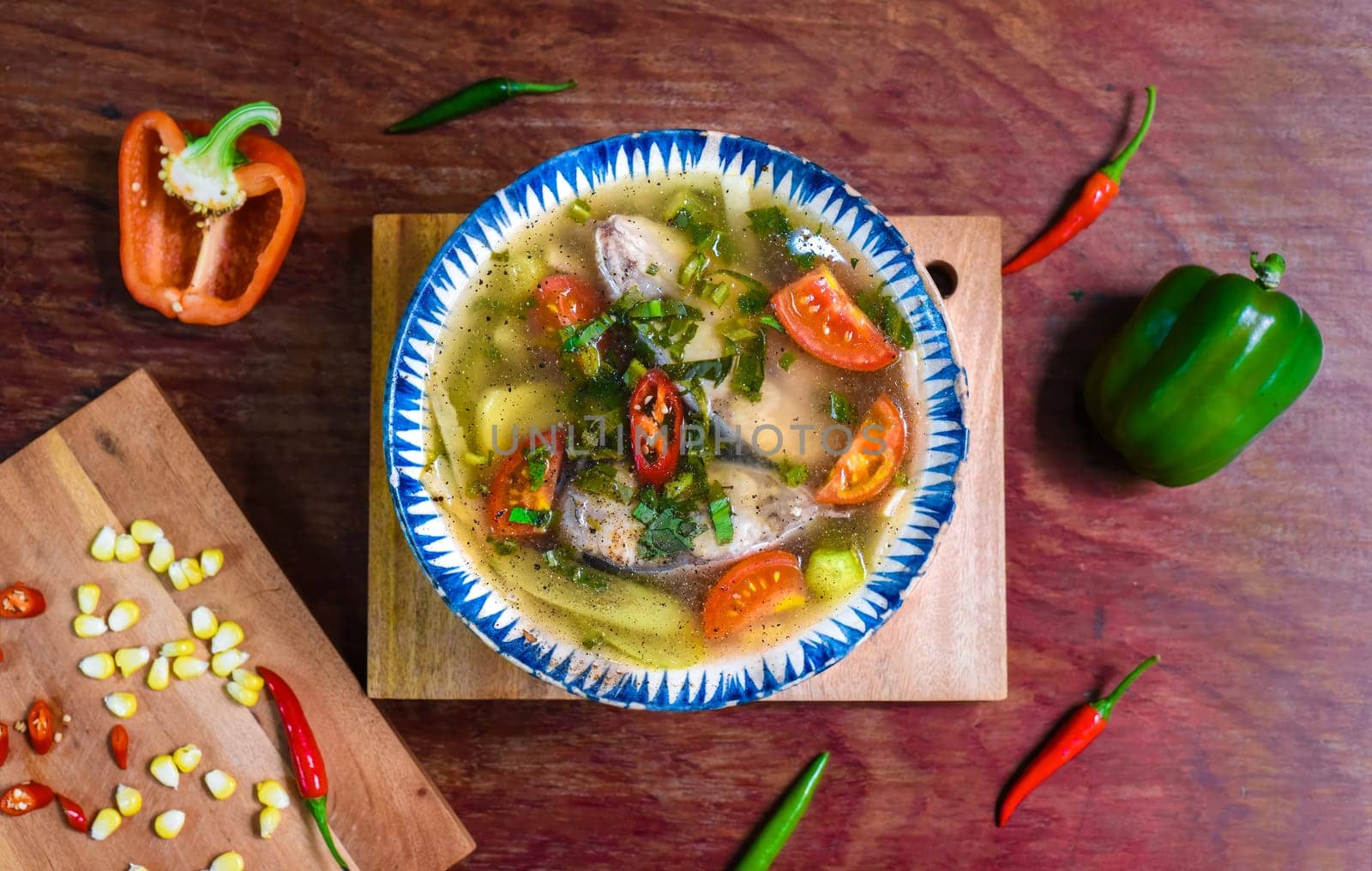 Vietnamese soup with fish and vegetables on wooden table