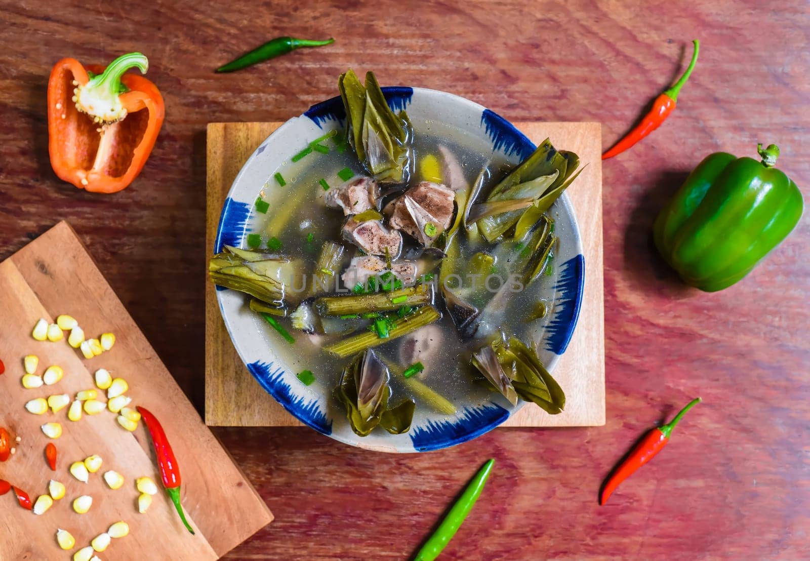 Vietnamese soup with fish and artichoke on wooden table