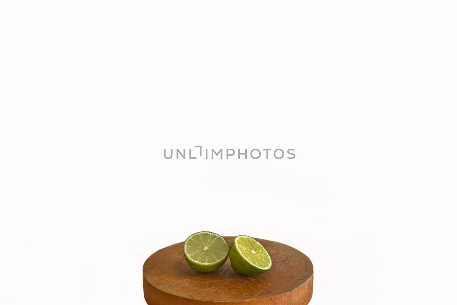 Lime fruit on wooden desk on white background