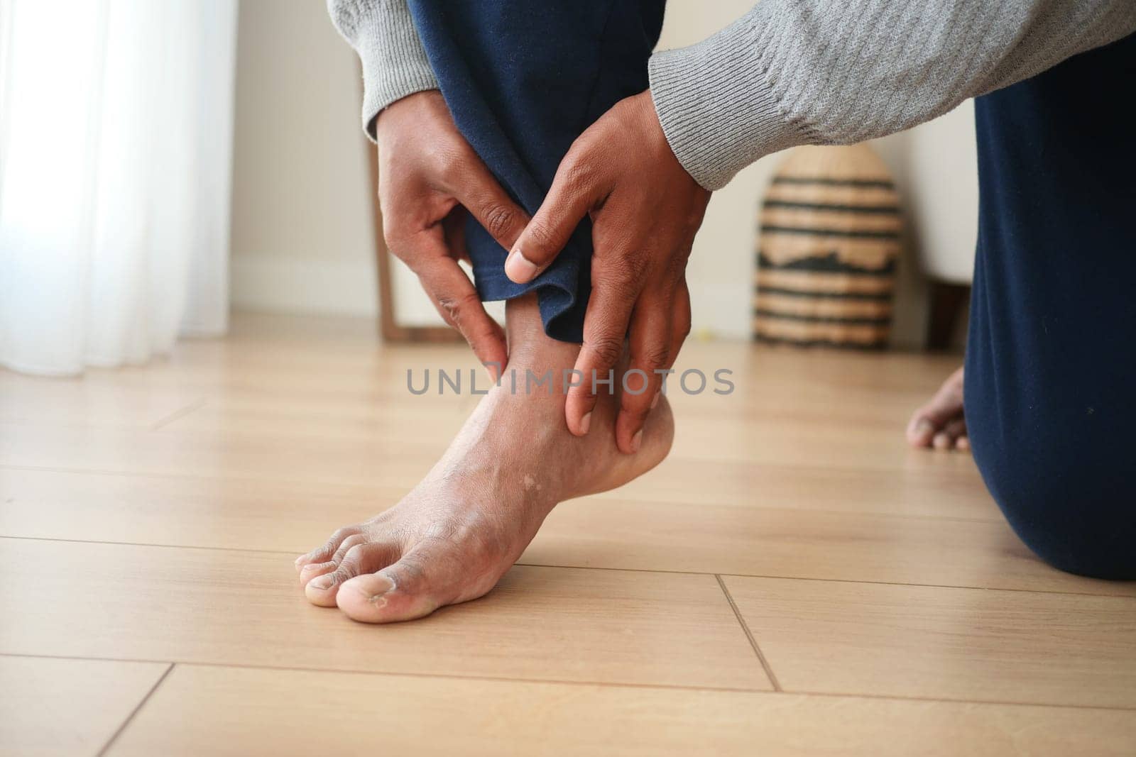 Person applies pressure on ankle for relief at home.