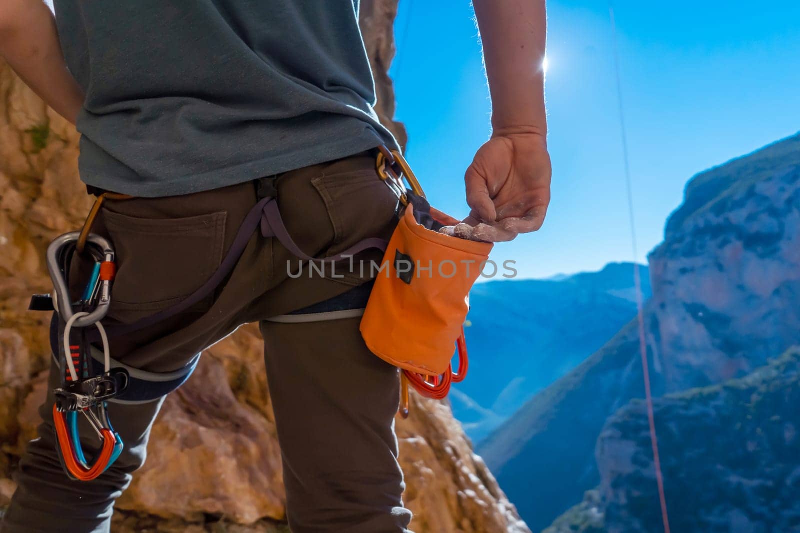 Male hand with magnesia powder close-up, against the background of beautiful mountains, the hand of climber who prepares for training outdoors, a man climbs in Twin Caves, Greece on a sunny day.