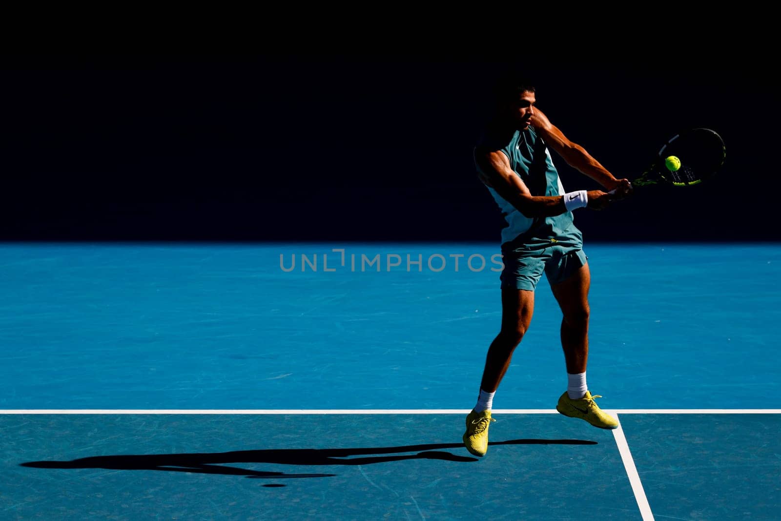 MELBOURNE, AUSTRALIA - JANUARY 19: Carlos Alcaraz of Spain hits a backhand to Jack Draper of Great Britain on day eight of the 2025 Australian Open at Melbourne Park on January 19, 2025 in Melbourne, Australia.