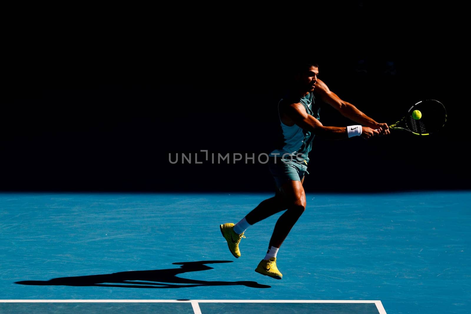 MELBOURNE, AUSTRALIA - JANUARY 19: Carlos Alcaraz of Spain hits a backhand to Jack Draper of Great Britain on day eight of the 2025 Australian Open at Melbourne Park on January 19, 2025 in Melbourne, Australia.