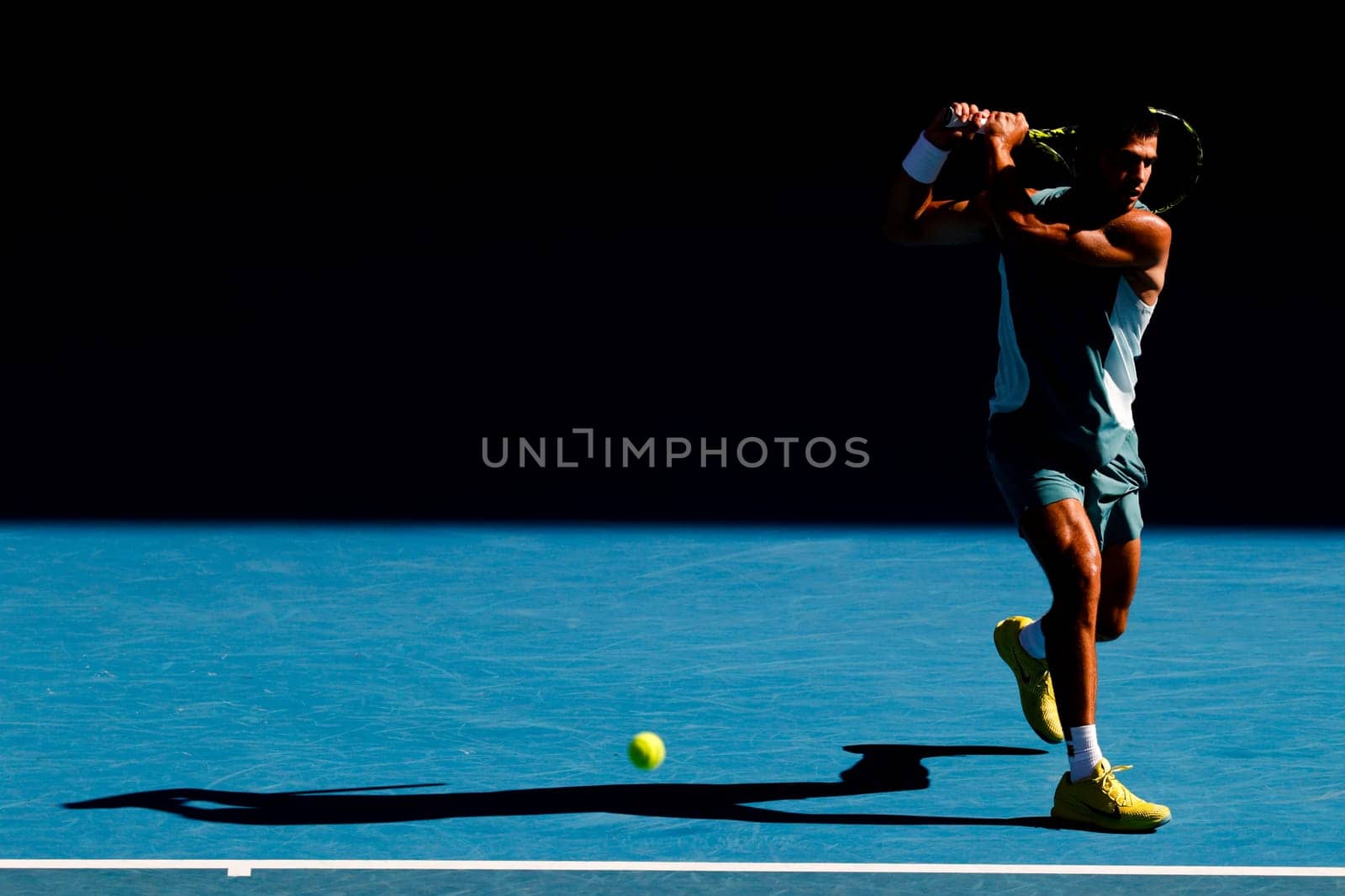 MELBOURNE, AUSTRALIA - JANUARY 19: Carlos Alcaraz of Spain hits a backhand to Jack Draper of Great Britain on day eight of the 2025 Australian Open at Melbourne Park on January 19, 2025 in Melbourne, Australia.