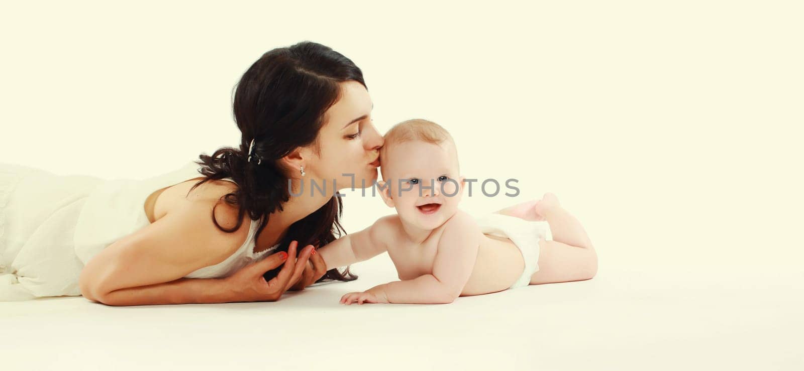 happy young mother playing with baby lying on the floor at home