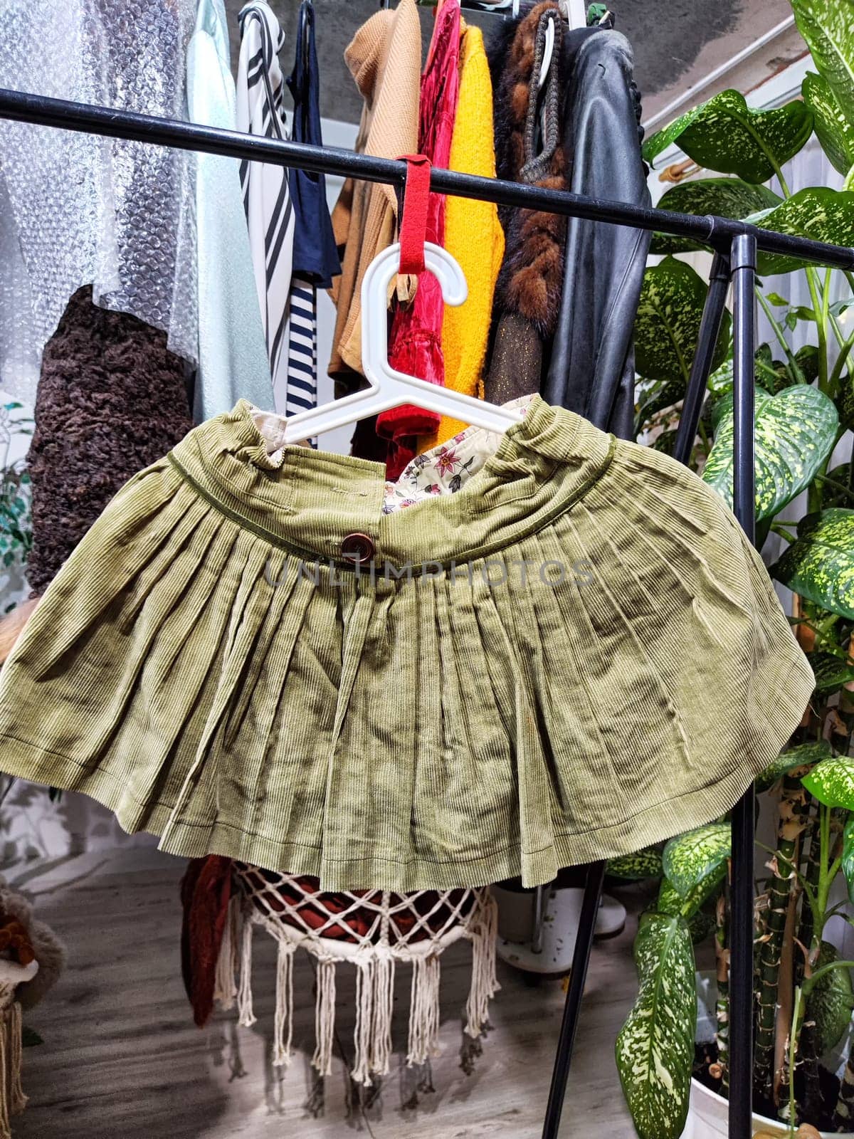A variety of second-hand clothing items displayed for sale at a private garage sale, emphasizing eco-friendly choices.