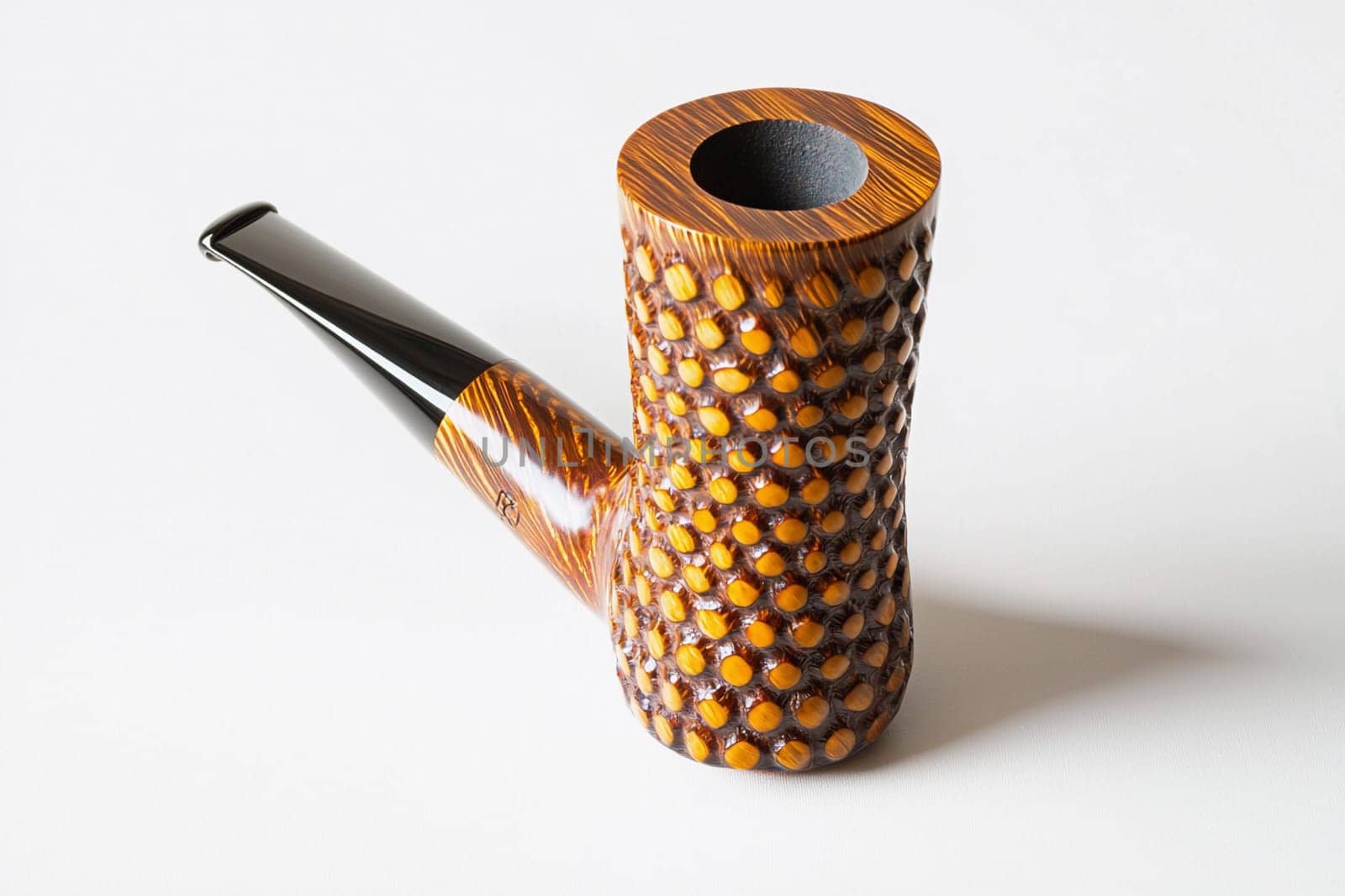 A beautifully crafted smoking pipe showcases its detailed texture and elegant shape.